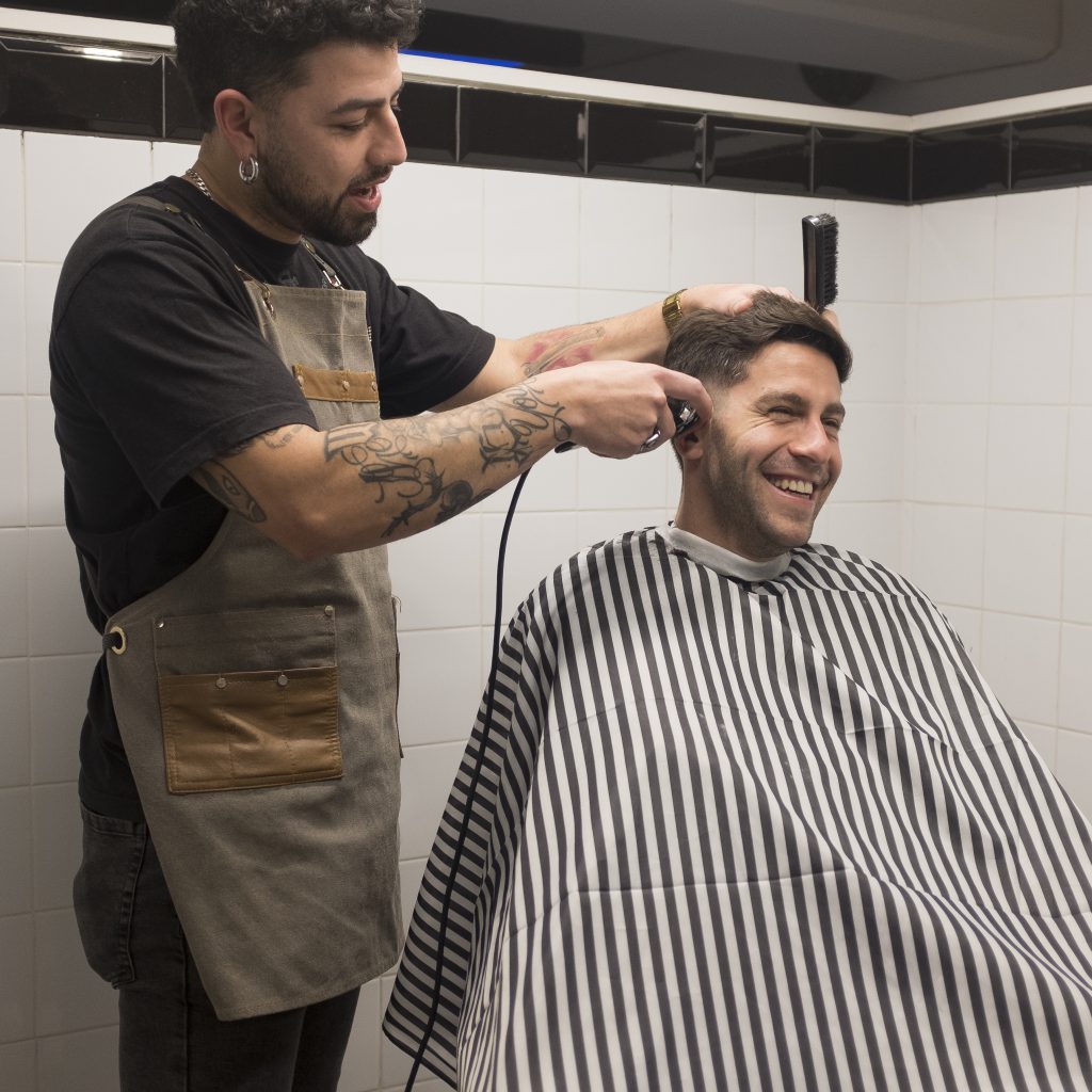 Barbero realizando un corte de cabello en Groom